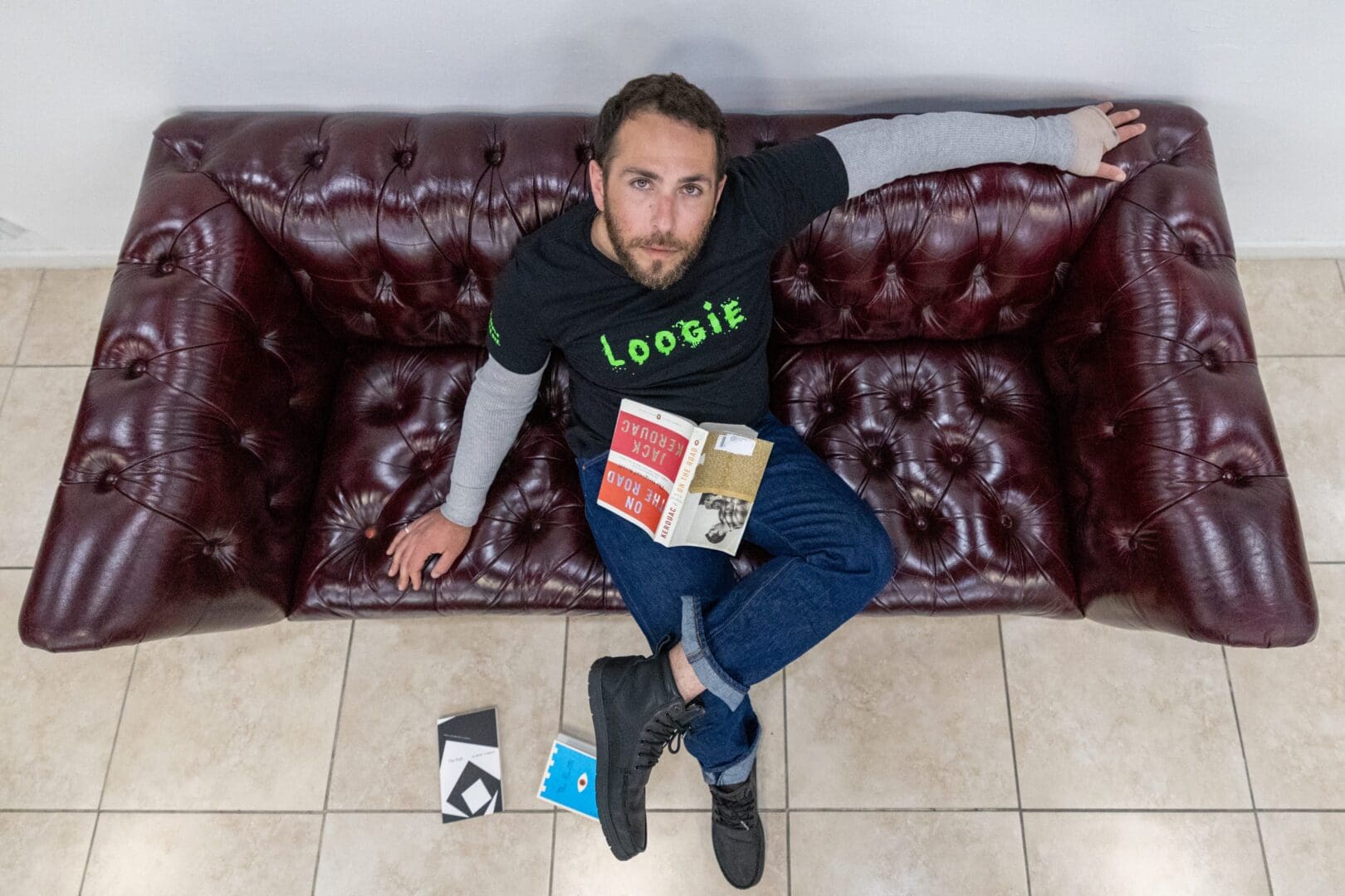 A man sitting on top of a couch with his feet up.