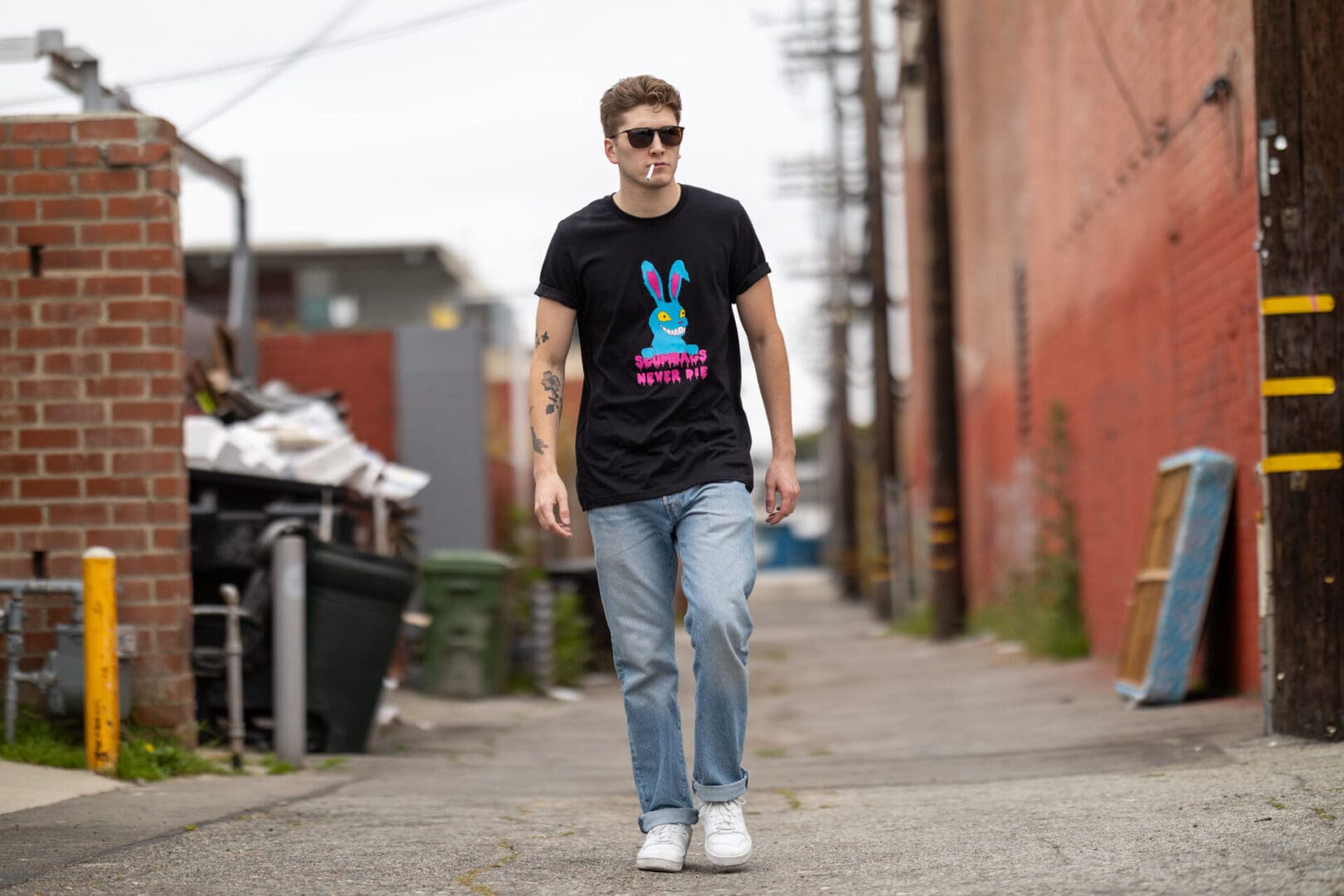 A man in jeans and sneakers walking down the street.